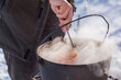 © T.Den_Team - Outdoor winter cooking, man preparing food in cauldron