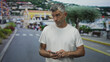 © Krakenimages.com - Man middle age grey hair in white t shirt tapping smartphone with right thumb while looking down on a street near harbor and crosswalk; thoughtful concentration.