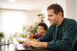 © Jelena - Father working on laptop with son having snack