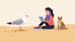 © Fauzan - Woman with dog and seagull sitting on sand, reading on tablet