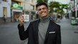 © Krakenimages.com - Young man outdoors in city street holding 'i am the boss' mug with a confident smile, showcasing modern urban lifestyle and casual attitude in dynamic urban environment.