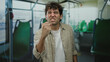 © Krakenimages.com - Hispanic man expressing anger inside a bus with his fist raised, portraying emotion in a public transport setting.