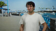 © Krakenimages.com - Hispanic man displaying a disgusted expression outdoors on a sunny street with palm trees and a blue sky in the background.