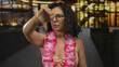 © Krakenimages.com - Woman in bikini with hawaiian lei gives thumbs down gesture on street at night; disapproval disappointment.