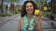 © Krakenimages.com - Woman enjoying outdoors in a park holding a yellow piggy bank while wearing a bikini and hawaiian lei looking confident and happy in the refreshing green environment.