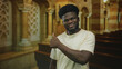 © Krakenimages.com - Man giving thumbs up with visible hand inside catholic church nave smiling toward camera; faith approval joy.