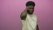 © Krakenimages.com - Young african american man touching neck with hand in studio for neck pain and stiffness while wearing a light tshirt and showing a pained expression; discomfort relief.