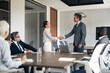 © Jelena - Business professionals shaking hands reaching partnership agreement in meeting