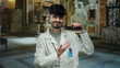 © Krakenimages.com - Young man in museum wearing lab coat showcasing dental model with confident smile indoors.