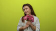 © Krakenimages.com - Woman smiling holding bouquet of pink flowers against vibrant yellow background wearing casual attire conveying joy and serenity with subtle tattoo visible on her arm.