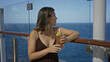 © Krakenimages.com - Woman sipping an iced cocktail with straw at cruise ship deck rail, leaning on wooden rail with lemon garnish and glass visible; relaxation.