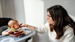© ADDICTIVE STOCK - Baby led weaning with attentive mother feeding child