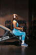 © ADDICTIVE STOCK - Woman exercising in hotel gym with dumbbells and headphones
