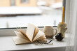 © ADDICTIVE STOCK - Cozy reading nook with book and mug on windowsill