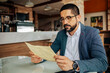 © kleberpicui - Business man reading menu in cafe. Concepts of remote work, freelance lifestyle, business routine, urban life and modern professional