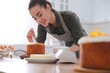© New Africa - Young woman decorating traditional Easter cake with glaze in kitchen