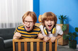 © New Africa - Two cute brothers in armchair at home