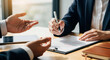 © Hendra - Business meeting where a person signs a contract with a pen while another person gestures