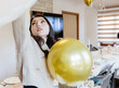 © Nataliya - A beautiful girl holds a golden balloon in her hands.