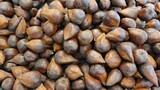 Close up of a pile of snake fruit being sold at the market in the background.