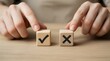 © SAYEM - Hands choosing between two wooden blocks with checkmark and cross symbols on a wooden table