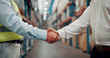 © SparkPix/peopleimages.com - Business people, meeting and warehouse with handshake for partnership, b2b or deal in logistics. Employees, colleagues or shaking hands with agreement for storage control, shipping or supply chain
