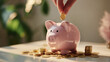 © Lumi Stock Studio - A minimal and clean financial stock photo featuring a close-up of a human hand placing a gold coin into a pink ceramic piggy bank, surrounded by scattered coins, symbolizing savings and investment.