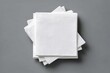 © azka - A stack of clean, white, folded paper napkins arranged on a neutral grey background