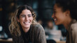 © Sajib - Two smiling young women chatting and laughing together in a modern office setting indoors