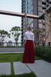 © blackday - Woman standing in modern residential courtyard surrounded by high rise buildings