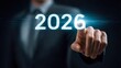 © Oleh - Businessman pointing at glowing 2026 on a futuristic digital interface, symbolizing planning, future vision, business strategy, and technological advancement in goal setting