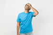 © khosrork - Portrait of sad upset unshaven man wearing blue T- shirt standing expressing sadness, showing facepalm gesture, forgot something important. Indoor studio shot isolated on gray background.
