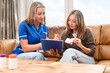 © Iryna - Nurse talks to patient at home during health assessment on a sunny day