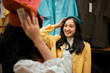 © Parichat - Young woman enjoying shopping trying on clothes in store