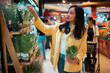 © Parichat - Woman choosing fresh produce in supermarket grocery store