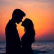 © Airin - A silhouetted couple embraces intimately against a vibrant colorful sunset over the ocean high quality