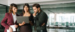 © Stock 4 You - Team of three colleagues, partners or coworkers smiling while reviewing project on laptop pc computer. Man women collaborating in office. Professional people working together. Web banner, copy space