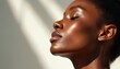 © Maryna - Close up profile of African American woman with radiant, hydrated melanin skin in soft natural light. Eyes closed in peacefulness, lips slightly parted showing smooth texture. Healthy face with