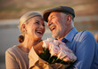 © Genowefa - Love, hug and old couple with flowers as a gift in celebration of a happy birthday, marriage and valentines day. Romance, smile and senior woman with elderly partner to celebrate retirement milestone