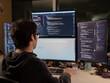 © Phanudat Manphatthan - Back View of Programmer Focused on Multiple Coding Screens