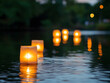 © Kufareesah - Glowing square paper lanterns float on calm dark water at night with ripples