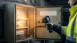 © Art_spiral - Industrial electrician performing infrared thermography inspection on electrical control cabinet wiring using thermal imaging camera predictive maintenance safety concept