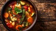 © hadia - Rustic vegetable stew brimming with carrots, zucchini, and herbs presented in a dark bowl.