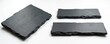 Set of three dark slate rectangular boards on a white background. These rustic stone plates have rough edges perfect for serving food. Use them as platters or cutting boards in your kitchen.