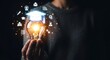 © Ans Creative - Education Innovation: Hand Holding Glowing Light Bulb with Graduation Cap and Floating Icons. Digital Knowledge, Successful Learning, and Idea Generation Concept.