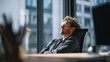 © Lumi Stock Studio - A weary office employee sitting alone at a desk in a slouched position with eyes closed, depicting workplace burnout, exhaustion, and mental fatigue in a modern corporate setting