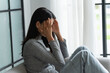 © Charlie's - Young Asian Woman Feeling Lonely Sad Sick Stressed on Sofa at Home Alone for Healthcare Wellness Lifestyle.