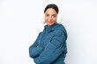 © luismolinero - Young hispanic woman wearing a winter earmuffs isolated on white background with arms crossed and looking forward