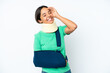 © luismolinero - Young hispanic woman wearing a neck brace and sling isolated on white background smiling a lot