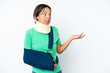 © luismolinero - Young hispanic woman wearing a neck brace and sling isolated on white background with surprise expression while looking side